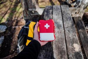 rot zuerst Hilfe Kit mit Medikamente, Tourist Ausrüstung Tasche mit Medikamente, zuerst Hilfe im das Wald im Natur, Camping Medizin. foto