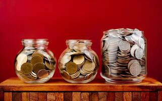 Speichern Münzen im ein Glas Krug, Ersparnisse Konzept, finanziell Planung und Investition Kasse fließen und Einkommen foto