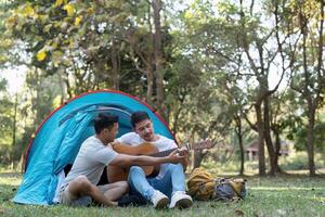 glücklich asiatisch männlich Fröhlich Paar auf Camping zusammen im ein Wald. romantisch Berufung Reise. lgbt Konzept foto