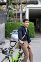 Öko freundlich, glücklich Lebensstil asiatisch jung Geschäftsmann Reiten Fahrrad gehen zu Büro Arbeit beim Stadt Straße mit Fahrrad im Morgen foto