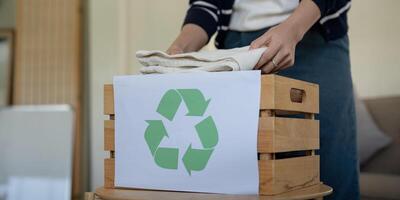 Frau Pack Box mit benutzt Kleider zum Wiederverwendung. wiederverwenden, Recycling Material und reduzieren Abfall im Mode, zweite Hand bekleidung Idee. kreisförmig Mode, Null Abfall Konzept foto