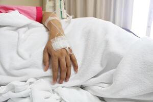 das Frau Patienten Hand Empfang das Kochsalzlösung Lösung. Gesundheitswesen und medizinisch Konzept. foto