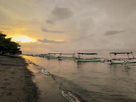 Angeln Boote Anker auf das Strand im das Nachmittag, wann das Sonnenuntergänge foto