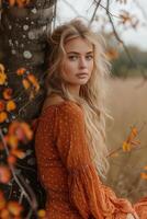 ai generiert schön blond Frau im rot orange Kleid posieren durch Baum mit bunt Blätter foto