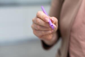 mit ein Hand halt das Stift zum Schreiben. foto