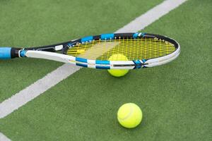 Tennis Ball und Schläger auf das Boden von sonnig draussen Gras Tennis Gericht. Sommer, gesund Lebensstil, Sport und Hobbys. foto