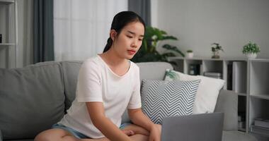 selektiv Fokus, jung attraktiv Frau ist mit Laptop zu Uhr online Yoga Lektionen Sitzung auf Sofa mit Augen geschlossen tun Meditation im das Leben Zimmer beim Zuhause foto