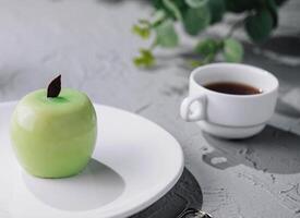 Apfel geformt Mousse Kuchen und Tee foto