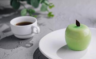 Grün Apfel geformt Mousse Kuchen und Tasse von Kaffee foto