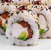 Sushi Rollen mit roh Thunfisch und Avocado bestreut mit Sesam foto