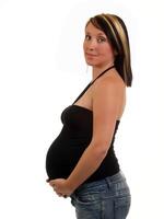 jung schwanger Frau mit groß Bauch im schwarz oben foto