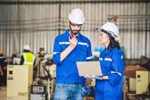 Mechaniker des Ingenieurteams, der den Roboterarm der Computersteuerung zum Schweißen von Stahl in der Werkstatt der Stahlfabrik verwendet. Programmiersoftware für Industrieroboter für die automatisierte Fertigungstechnik foto