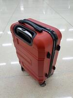 ein rot Koffer mit schwarz Linien auf das Reißverschluss und Räder ist sehr geeignet zum lange Reisen oder Reise foto