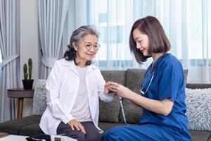 Senior Frau erhalten medizinisch Bedienung Besuch von Pflegekraft Krankenschwester beim Zuhause während haben Ergebnis von medizinisch Prüfung von Impuls Oximeter zum Gesundheit Pflege und die Pension Wohlergehen Versicherung foto