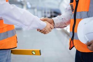 Mannschaft von Ingenieur ist haben und Handschlag nach erledigt inspizieren das Konstruktion Projekt zum modern die Architektur und echt Nachlass Entwicklung Hand Über Verwendungszweck foto