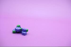 lila Hintergrund mit Traube Spielzeuge. traubenförmig Radiergummi isoliert auf lila Hintergrund. foto