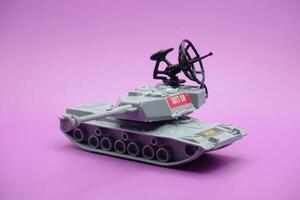 grau Spielzeug Panzer isoliert auf lila Hintergrund. Nachahmung von ein Panzer häufig benutzt durch das bewaffnet Kräfte. foto