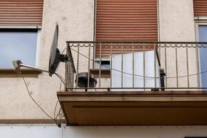 ein alt Haus mit ein Balkon und ein Satellit Gericht foto