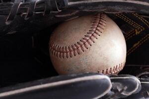 Nahansicht von alt Baseball im schwarz Handschuh foto