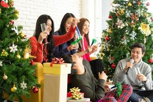 Gruppe schöner asiatischer junger Leute in Weihnachtsfeier foto