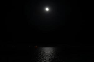 ein dunkel Nacht Himmel mit ein voll Mond foto