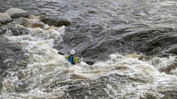 Kajakfahrer Surfen das Welle im Wildwasser Park auf das Puder Fluss im Innenstadt von Fort Collins, Colorado foto