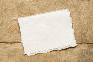 Blatt von leer Weiß khadi Lappen Papier gegen abstrakt Landschaft im Erde Töne foto