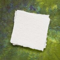 klein Platz Blatt von leer Weiß khadi Papier gegen bunt marmoriert Papier foto