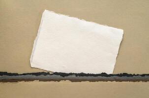 klein Blatt von leer Weiß khadi Lappen Papier von Indien gegen abstrakt Landschaft im Erde Töne foto