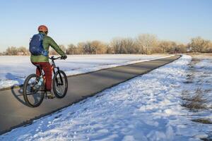 männlich Radfahrer auf ein Fahrrad Weg im Winter Landschaft - - Puder Fluss Weg im Nord Colorado, Radfahren, Erholung und pendeln Konzept foto