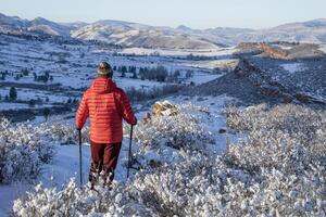 männlich Wanderer im Winter Landschaft von felsig Berge Ausläufer im Nord Colorado, lory Zustand Park foto