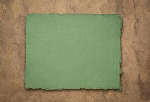 Grün und braun abstrakt - - ein Blatt von leer indisch handgemacht Lappen Papier gegen texturiert Rinde Papier, Kopieren Raum foto