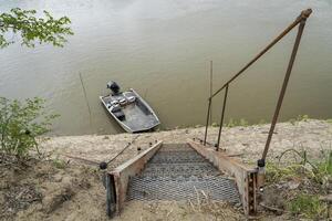 steil Metall Treppe führen Nieder zu Wasser und ein Angeln Boot auf ein Ufer von das Missouri Fluss beim Lupus, mo foto