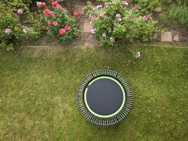 Mini Trampolin zum Fitness ausüben und abprallen im ein Hinterhof, Antenne Aussicht im Sommer- foto