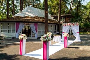 stilvoll Hochzeit Bogen im das Park zum das Zeremonie. Rosa und Weiß Blumen. foto