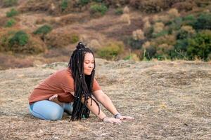 jung Frau ist Sitzung im das Lotus Position und tun Yoga auf Berg oben. Konzept von gesund Lebensstil. foto