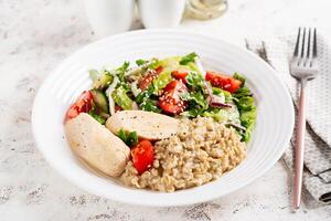 Frühstück Haferflocken Haferbrei mit gekocht hausgemacht Hähnchen Würstchen und frisch Salat. gesund ausgewogen Lebensmittel. modisch Lebensmittel. foto