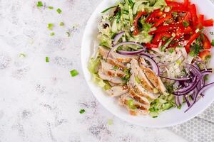 frisch Salat mit gegrillt Hähnchen Brust, Filet und Kopfsalat, daikon, rot Zwiebeln, Gurke und Sesam. gesund Mittagessen Speisekarte. Diät Lebensmittel. oben Aussicht foto