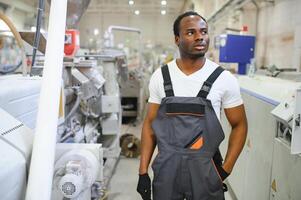 Industriearbeiter drinnen in der Fabrik. junger Techniker mit orangefarbenem Schutzhelm foto