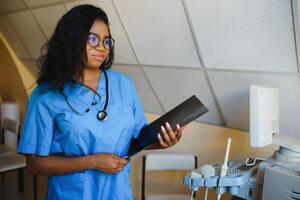 attraktiv weiblich afrikanisch amerikanisch medizinisch Fachmann im Büro foto