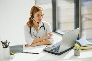 jung weiblich Arzt reden zu geduldig online von medizinisch Büro. Arzt Beratung Klient auf Video Plaudern Laptop beim Krankenhaus. foto