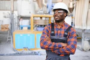 industriell Arbeiter drinnen im Fabrik. jung Techniker mit Weiß schwer Hut foto