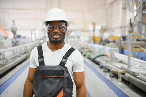 Fachmann schwer Industrie Ingenieur Arbeiter tragen Uniform, Brille und schwer Hut im ein Fabrik foto