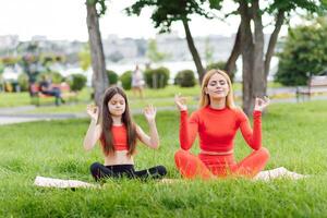 Mama und Kind im das Lotus Position auf das Natur foto