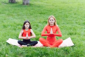 Mama und Kind im das Lotus Position auf das Natur foto