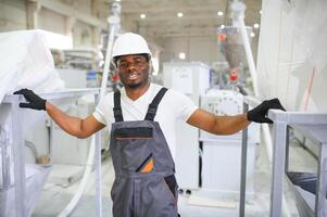 Fachmann schwer Industrie Ingenieur Arbeiter tragen Uniform, Brille und schwer Hut im ein Fabrik foto