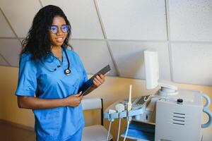 ziemlich weiblich afrikanisch medizinisch Krankenschwester halten Zwischenablage foto