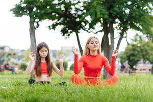 Mama und Kind im das Lotus Position auf das Natur foto