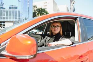 schön reifen Frau im Geschäft passen Fahren ein Auto zu Büro. Geschäftsfrau Fahrt ein Auto im Stadt. foto