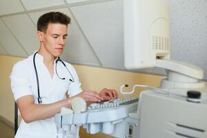 Arzt mit ein modern Ultraschall Wandler im das Klinik foto